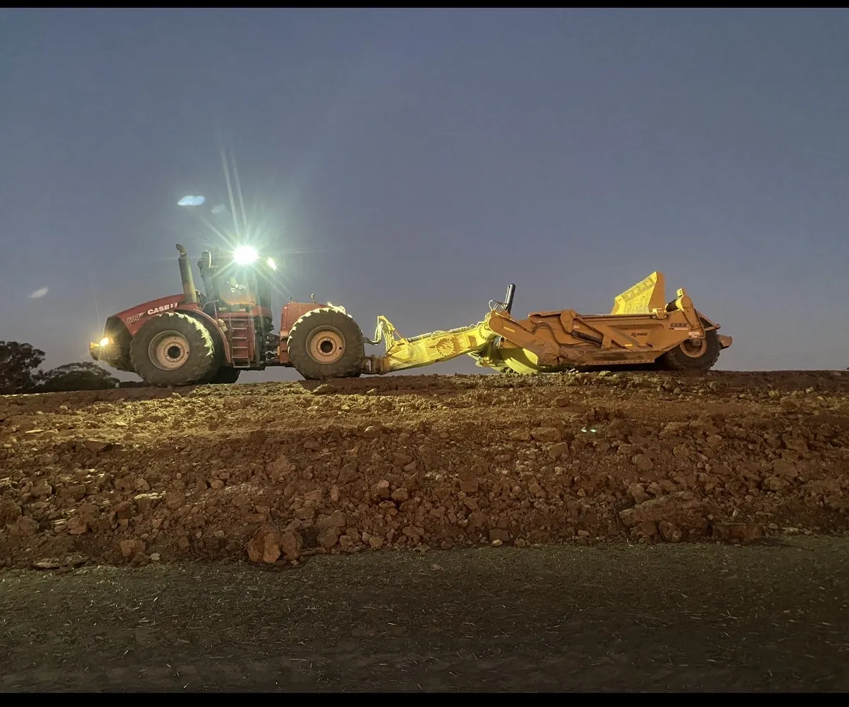 Articulated dump truck and scraper tuned by Southern Diesel Tuning, working at dusk